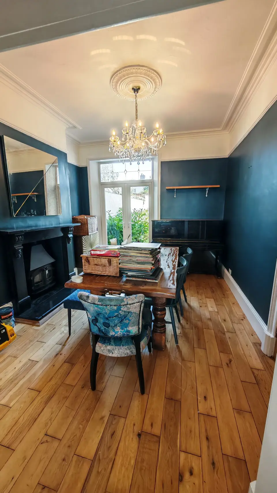 Dining room in deep teal with the ceiling rose and coving picked out in white