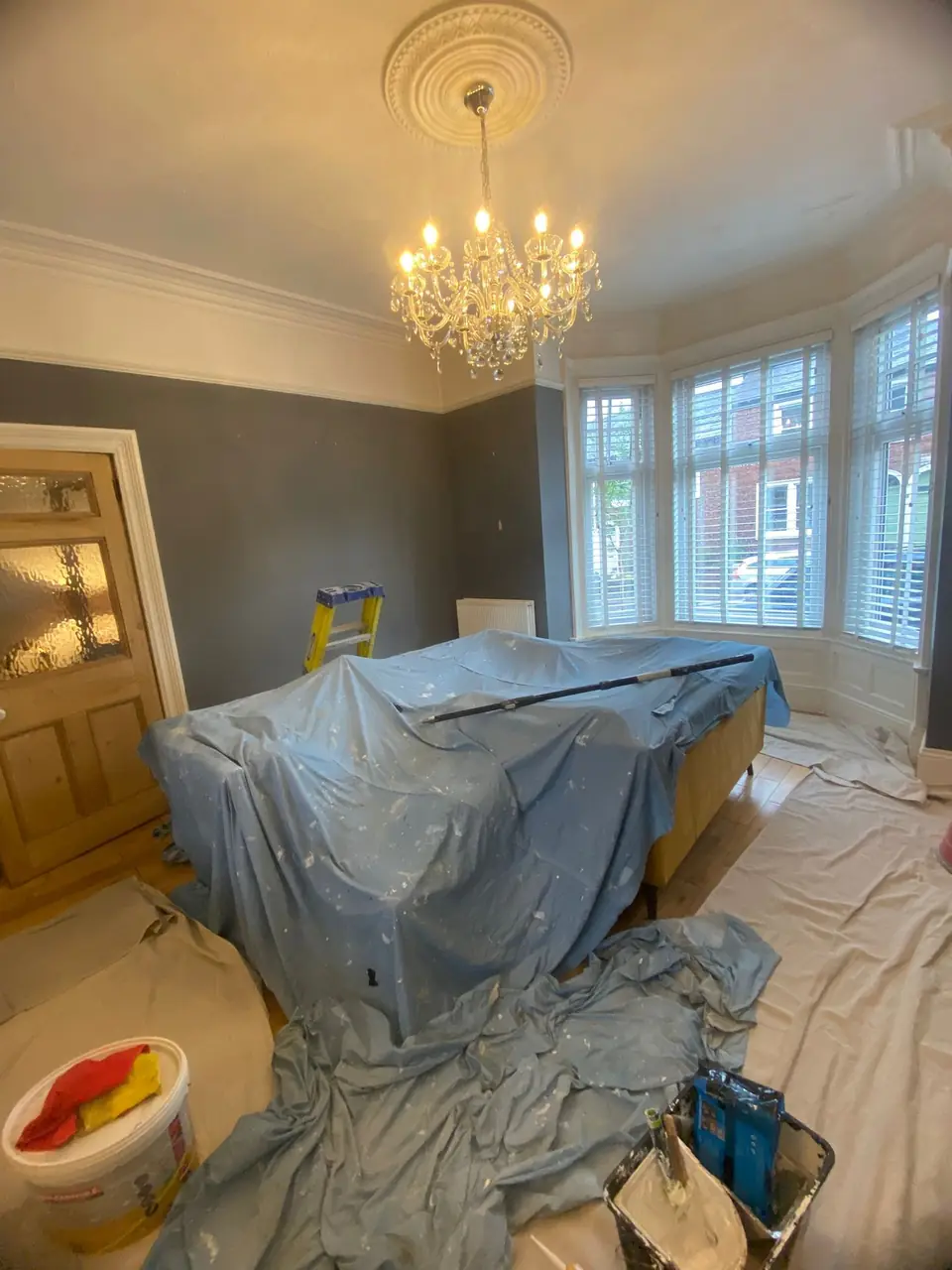 Before: grey lounge with the furniture fully protected