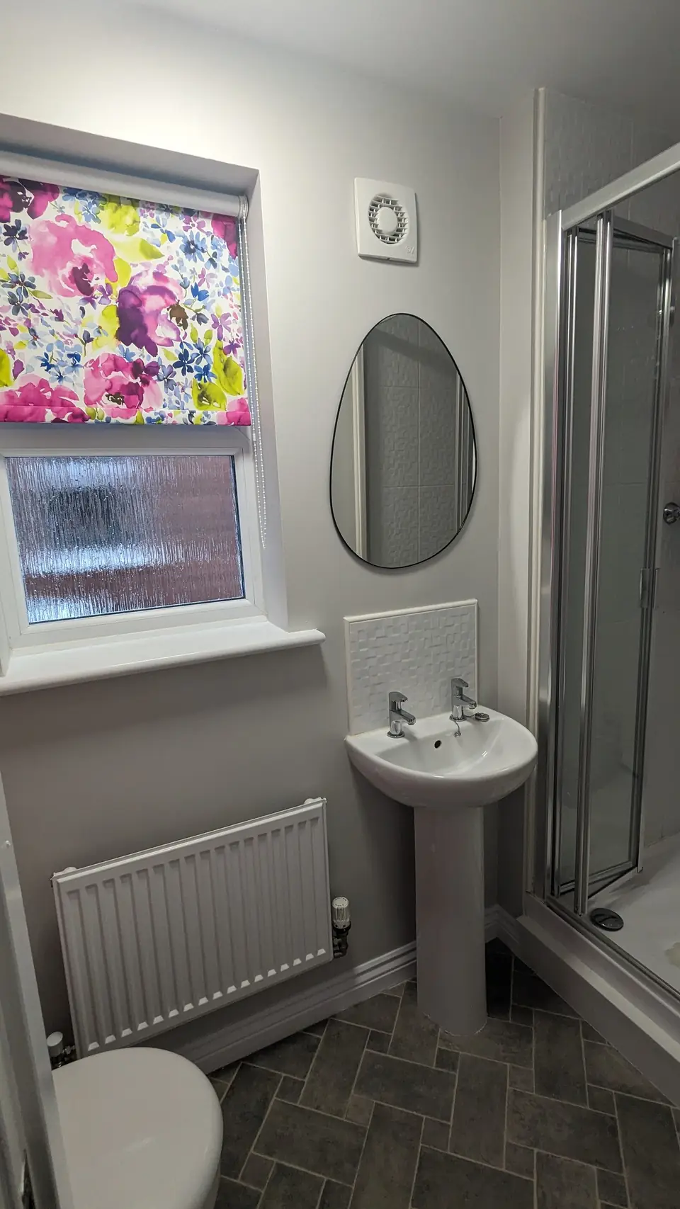 WC basin wall in soft grey with floral blind