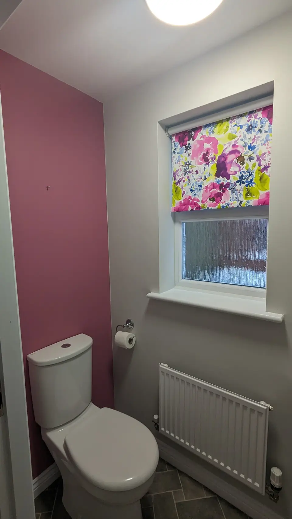 WC with raspberry pink feature wall and floral blind