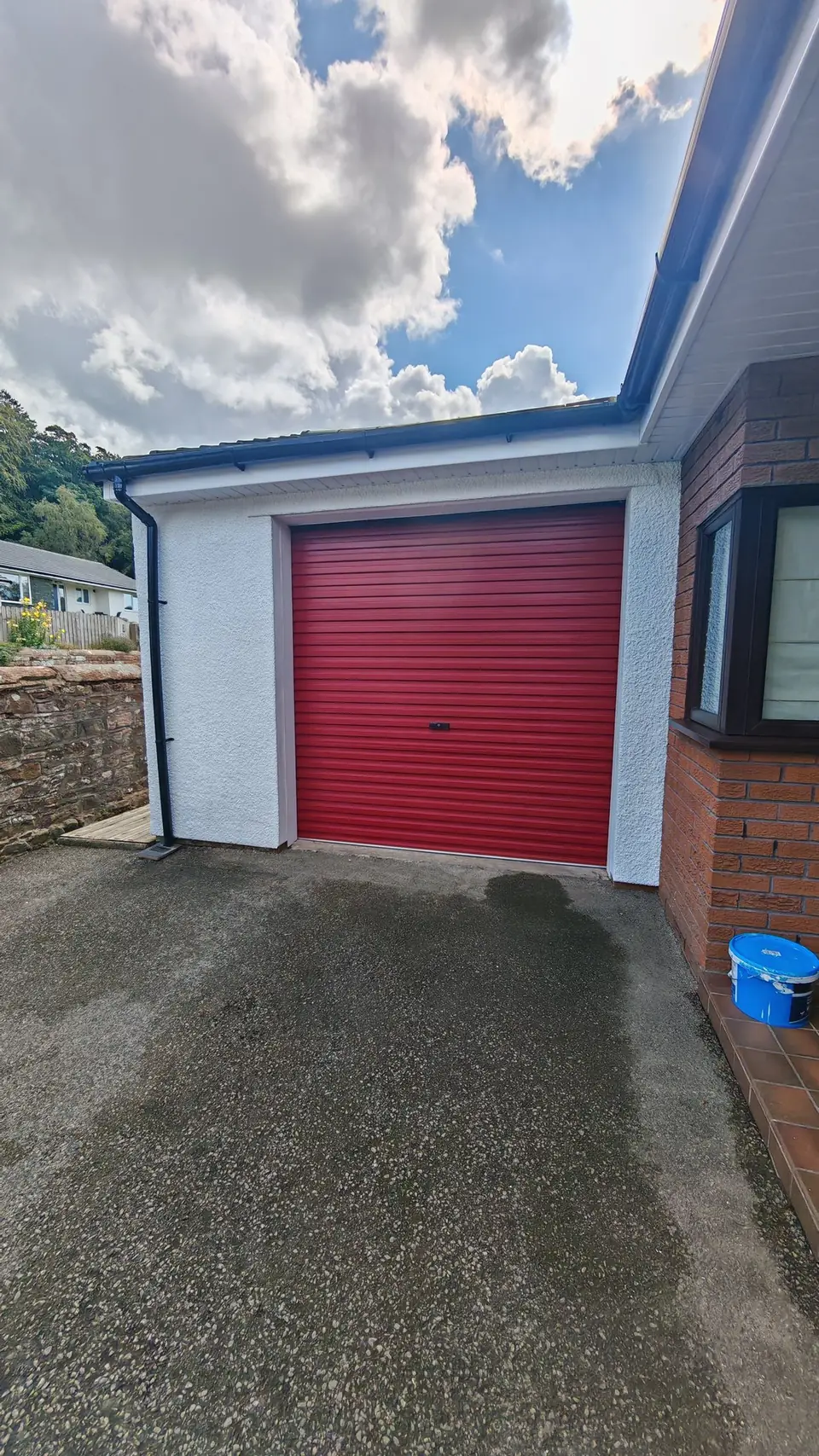 After: white render framing the red garage door