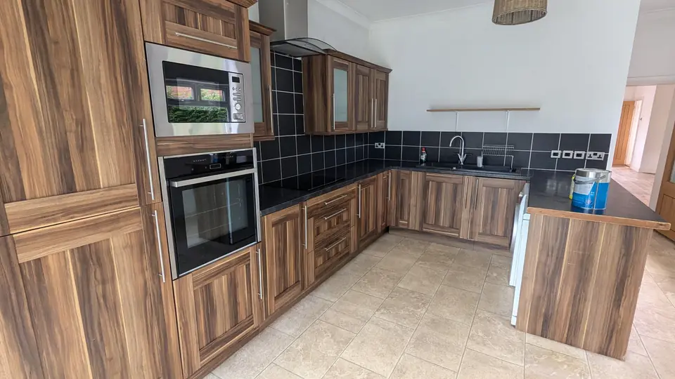 Before: woodgrain kitchen corner with tall oven housing