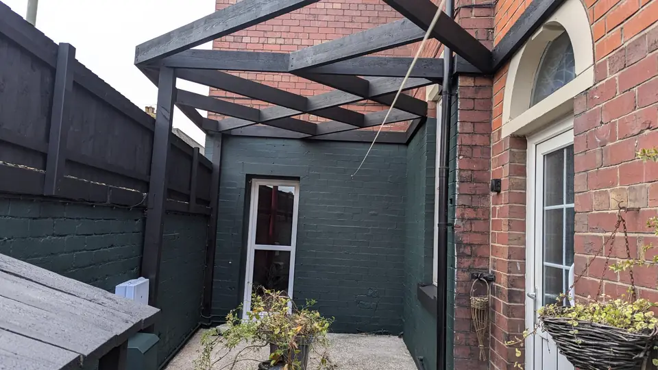 Back yard walls and pergola painted dark green