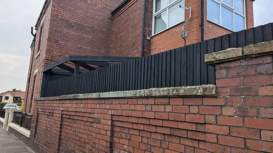 Dark green painted timber screen on the yard wall